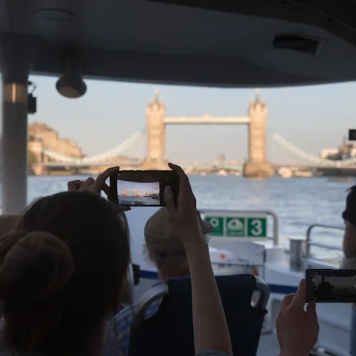 Passenger photographing Tower Bridge from a boat
