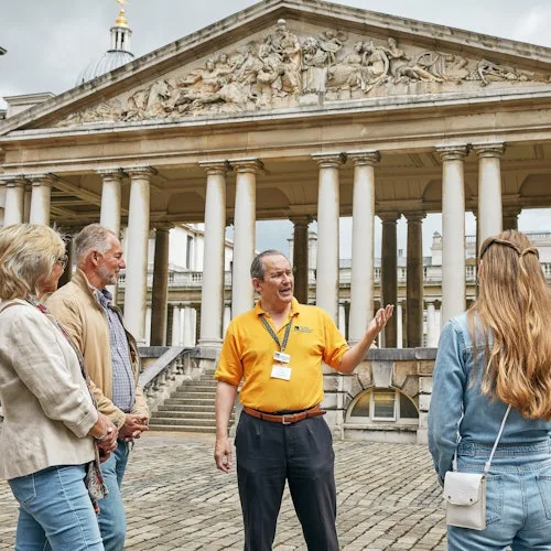 Visitors and guide beneath the Old Royal Naval College colonnades in Greenwich