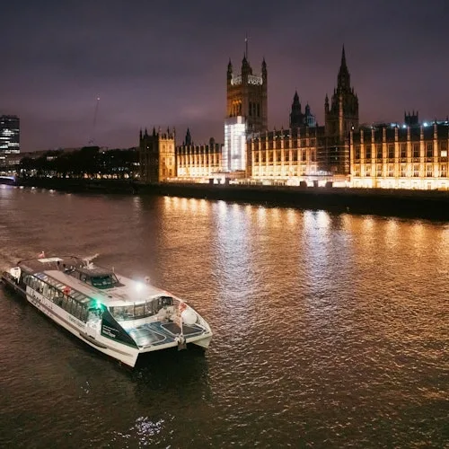 River boat beside the Houses of Parliament at night
