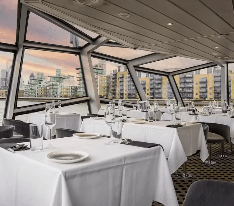 Window-lined dining room aboard a Thames cruise boat