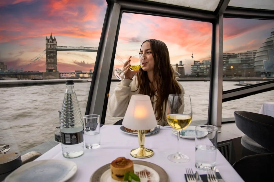 Dinner cruise passenger looking towards Tower Bridge at sunset