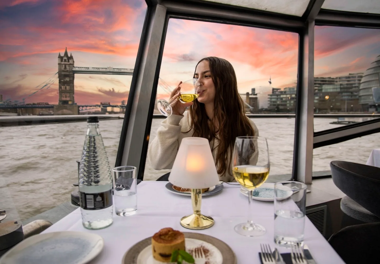 Dinner cruise passenger looking towards Tower Bridge at sunset