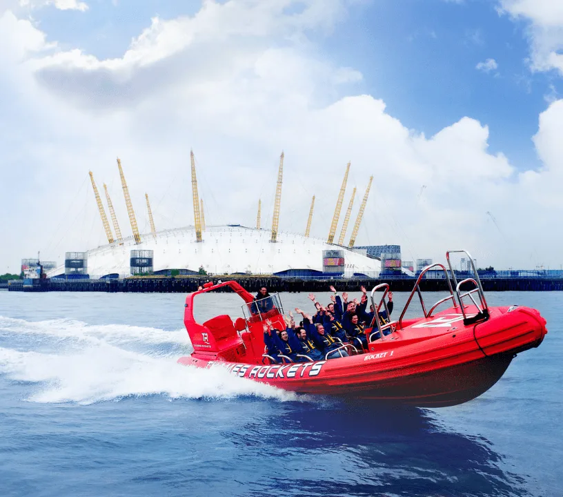 Red speedboat travelling near The O2